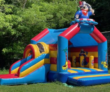 Pelouse avec château gonflable et toboggan au camping Les Foulons