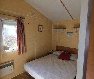 Chambre double avec lit et fenêtre dans le Camping Baroudeurs