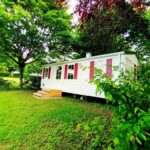 Mobil-home sur pelouse ombragée au Camping Baroudeurs