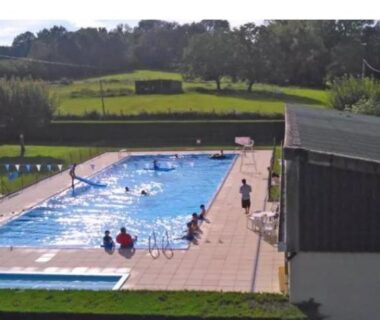 Piscine extérieure avec baigneurs et transats au Camping Baroudeurs