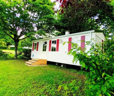Mobil-home sur pelouse ombragée au Camping Baroudeurs