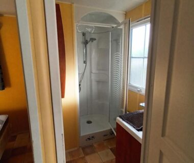 Salle de douche avec cabine et lavabo dans l'hébergement du Camping Baroudeurs