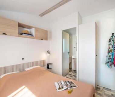 Chambre avec lit et salle d'eau au Camping Bel Air