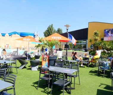 Terrasse et piscine extérieure avec parasols au Camping Bel Air