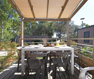 Terrasse en bois avec table et chaises sous pergola du camping Bella Vista