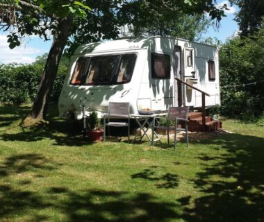 Emplacement herbeux avec caravane et coin salon au Camping Belle Vue