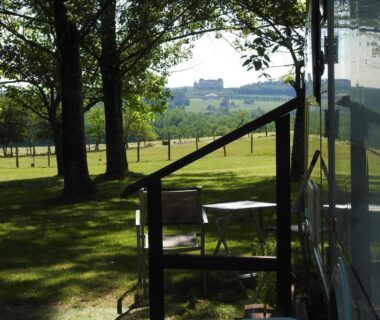 Terrasse ombragée avec table et chaises au Camping Belle Vue