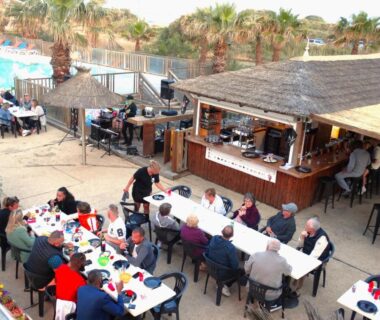 Terrasse extérieure avec tables et bar près de la piscine au Camping Bleu Marine