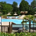 Piscine extérieure avec parasols et transats au Camping Calme et Nature Iserand