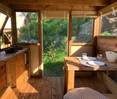 Intérieur de cabane en bois avec table dressée au Camping Calme et Nature Iserand
