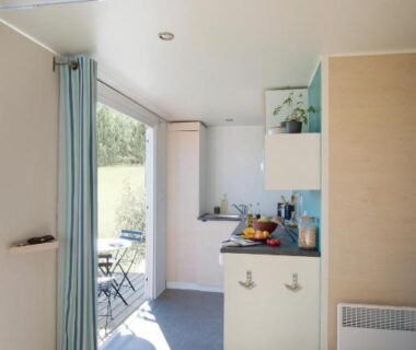 Intérieur de mobil-home avec kitchenette et terrasse ensoleillée au Camping Campo Di Liccia