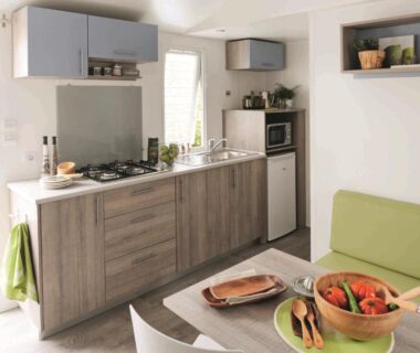 Intérieur du mobil-home avec cuisine équipée et coin repas au Camping Campo Di Liccia - Maeva