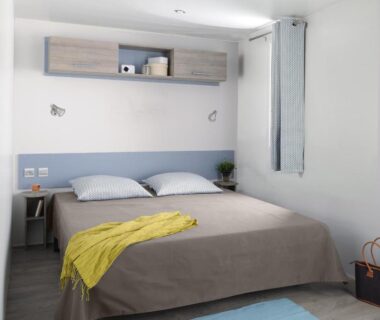 Chambre double claire avec lit et rangements au Camping Campo Di Liccia Maeva