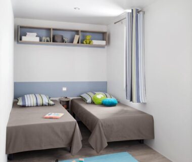 Chambre avec deux lits simples et jouets au Camping Campo Di Liccia - Maeva