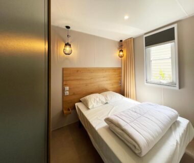 Chambre avec lit double et fenêtre au Camping Canal de Berry