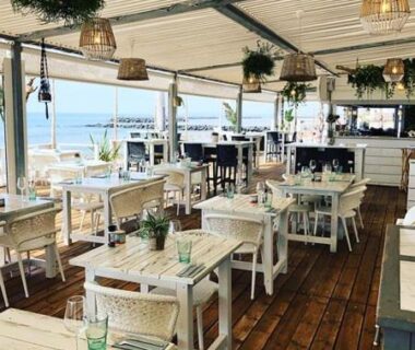 Terrasse sur deck avec tables face à la mer au Camping Carabasse Vias plage