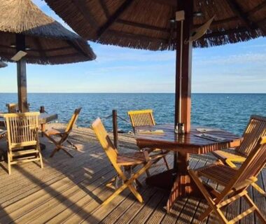 Terrasse en bois avec parasols chaises et tables au Camping Carabasse Vias plage