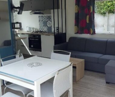 Intérieur salon avec table, canapé et kitchenette du Camping Caravaning Les Cerisiers Berck sur mer