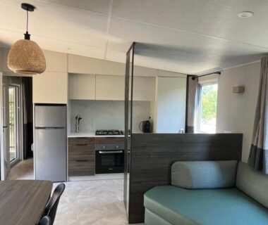 Intérieur mobil-home avec kitchenette et coin salon au Camping-Caravaning de la Mollière