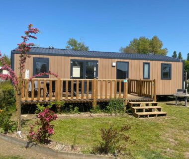 Mobil home avec terrasse en bois sur pelouse au Camping-Caravaning de la Mollière