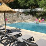 Piscine extérieure bordée de transats au Camping Chalets Les Chênes Verts