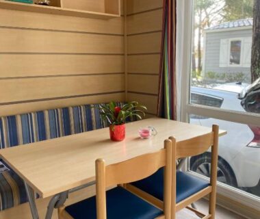 Intérieur de mobil home coin repas avec table et chaises au Camping Cœur De Vendée