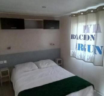 Chambre avec lit double et voilage bleu au Camping Cœur De Vendée