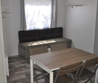 Intérieur avec coin repas banquette et table dans le Camping Corsica Paradise