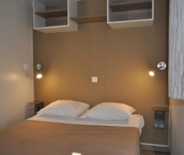 Chambre avec lit double et lampes de chevet au Camping Corsica Paradise