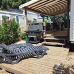 Terrasse en bois avec transats et barbecue au Camping DEL MAR Mobil Home Excellence