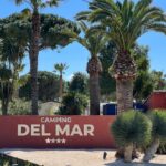Entrée avec panneau et palmiers au Camping Del Mar