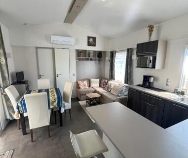 Intérieur salon et cuisine avec bar et coin repas du Mobile Home O'Hara Supérieur 1060 au Camping Del Mar 125