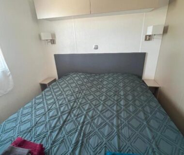 Chambre avec lit double et serviettes dans le Mobile Home O'Hara Supérieur 1060