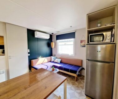 Salon avec kitchenette et canapé dans le mobil-home Camping Del Mar 52