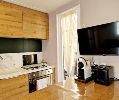 Coin cuisine avec TV et machine à café dans le Mobile Home Excellence du Camping Del Mar 52