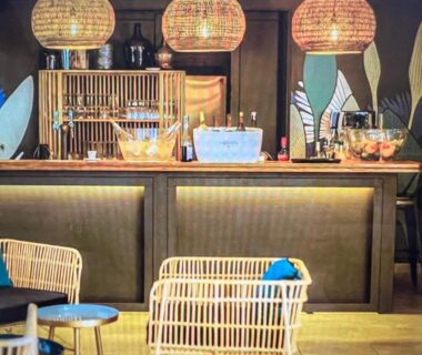 Bar intérieur avec comptoir et fauteuils en rotin au Camping Del Mar 64
