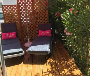 Terrasse en bois avec transats et parasol au Mobile Home Excellence Camping Del Mar B06