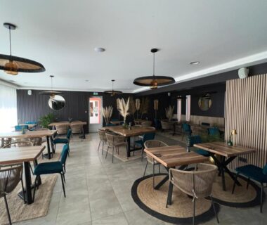 Salle de restaurant intérieure avec tables et suspensions du Camping Del Mar B07