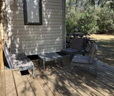 Terrasse en bois avec fauteuils et vélo du mobil-home Camping Del Mar B10