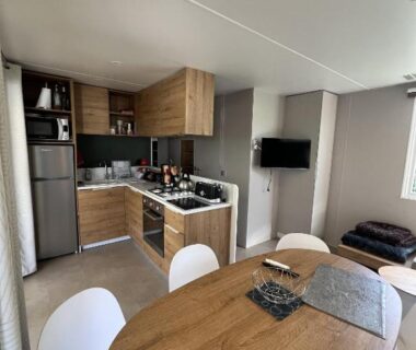 Intérieur de mobile home avec cuisine et coin repas dans le Camping Del Mar B70