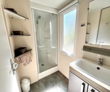 Salle d'eau avec cabine de douche et lavabo dans le logement du Camping Des Mimosas