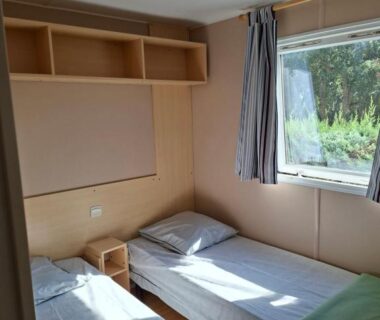 Chambre avec deux lits et fenêtre dans l'hébergement du Camping Des Mimosas