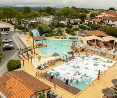 Piscine centrale avec toboggans et transats au Camping Domaine Berrua – Maeva Sélection