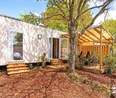 Terrasse dans un coin boisé avec mobil-home et pergola du Camping Domaine Berrua Maeva Sélection