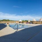 Piscine extérieure avec parasols et chaises longues au Camping Domaine Saâne et Mer