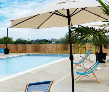 Piscine extérieure avec parasols et transats au Camping Domaine Saâne et Mer