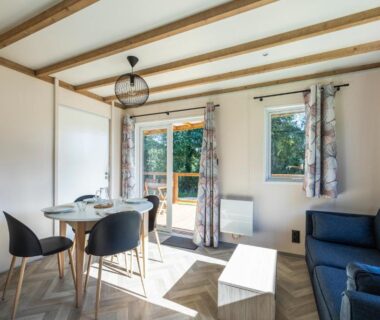 Intérieur de mobil-home avec coin repas et canapé au Camping Domaine Saâne et Mer
