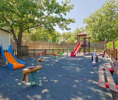 Aire de jeux avec toboggans et bancs au Camping Domaine Villa Verde
