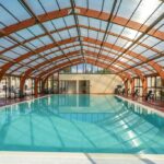Piscine couverte dans une verrière en bois au Camping Domaine d'Anghione