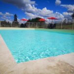 Piscine extérieure avec parasols au Camping Domaine de Mepillat